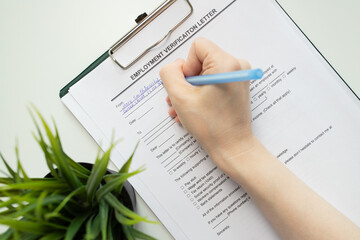 Employment verification letter, hand fills out a document, job recruitment, candidate interview.