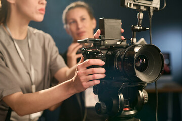 Close up of woman operating digital camera on set while directing video production copy space