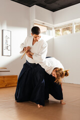 Martial Artist Demonstrating Knife Disarm With Joint Lock in Dojo