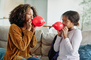 child mother family parent  daughter happy balloon party fun blowing teenage teen black african american celebration birthday blow playing kid together childhood girl mom