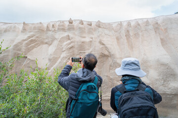 Tourists taking smartphone photos of cliffs at Valley of Ten Thousand Smokes.