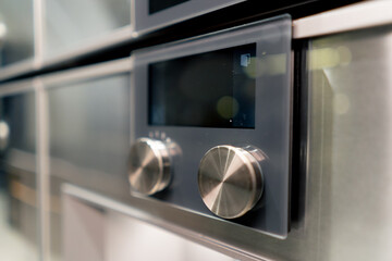 close-up of professional kitchen with a metal part of the oven with temperature and time switches