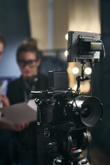 Vertical background image of pro digital video camera set up on stand in video production studio copy space