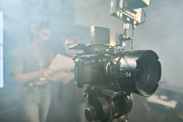 Background image of professional digital video camera on stand in video production studio with...