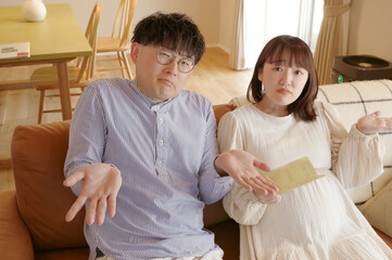 通帳を見ながら話し合いをする妊婦と男性