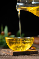 pouring olive oil into a glass bowl on table.