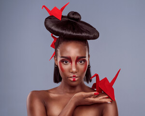 Portrait, cosmetics and black woman with origami for art, beauty or skin in studio isolated on gray...