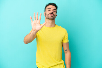 Young caucasian man isolated on blue background counting five with fingers