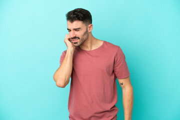 Young caucasian man isolated on blue background with toothache