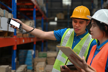 Two warehouse workers do stocktaking in a storehouse, Close-up, a warehouse management system,...