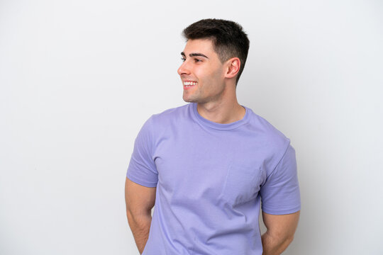 Young caucasian man isolated on white background looking to the side and smiling