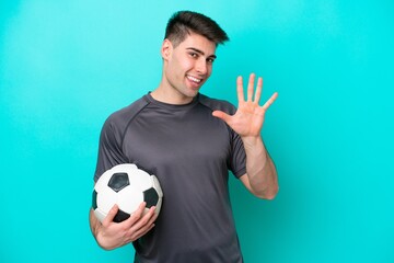 Young caucasian football player man isolated on blue background counting five with fingers