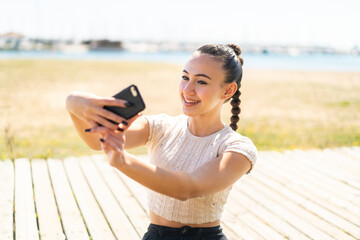 Young moroccan girl  at outdoors making a selfie with mobile phone