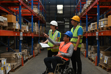 A disabled warehouse supervisor in a wheelchair manages the work with the team, business logistics...