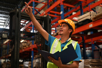 A male warehouse worker checks and counts the stock inventory in a warehouse, Warehouse management...