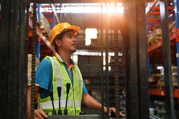 Close-up image of a male warehouse worker driving a forklift, Warehouse worker preparing products for shipment, and delivery in a warehouse