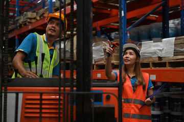 Two warehouse workers working in a Logistic distribution warehouse, Teamwork concept