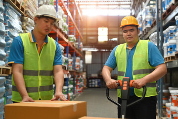 Distribution warehouse workers moving boxes on a hand truck loaded in Warehouse industrial stock storage