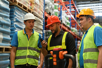 Smart Caucasian Foreman uses walkie talkie for operation with team in a factory warehouse
