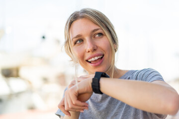 Young blonde woman at outdoors with sport watch