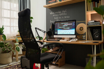 Workplace of modern musician, songwriter and performer with armchair standing in front of desk with...