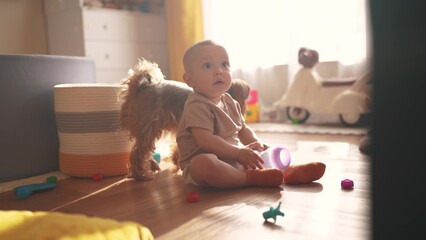 baby plays on the floor with toys. happy family kid dream concept. baby shakes a plastic bottle...