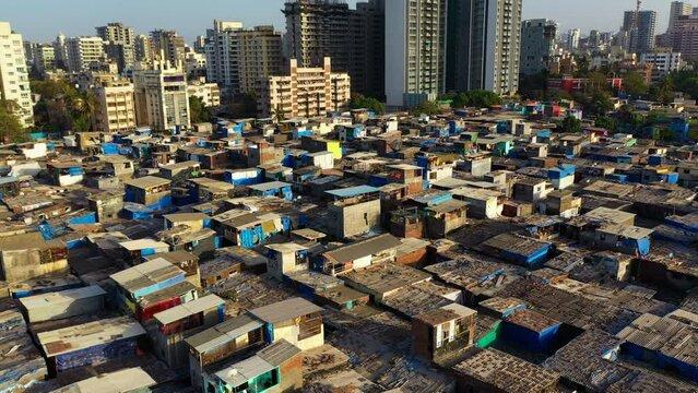 Drone tilting over the poor Gazdhar Bandh neighborhood, sunrise in Mumbai, India