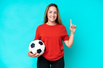 Young football player woman isolated on blue background pointing up a great idea