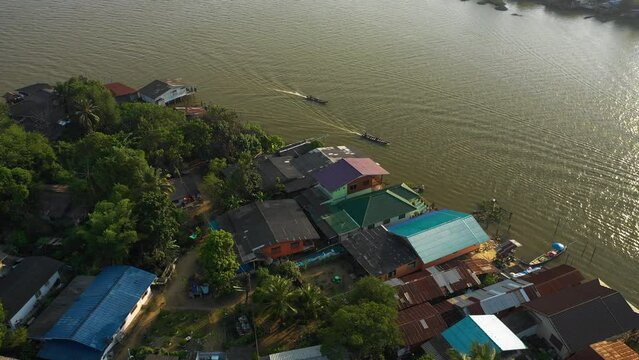 Aerial view circling boats in front of the cityscape of Surat Thani, Thailand