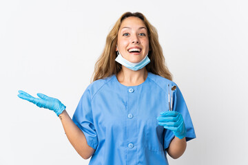 Woman dentist holding tools isolated on white background with shocked facial expression