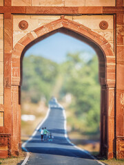 Travelling in India. A gate with a traditional Indian pattern and a road going into the distance. A...