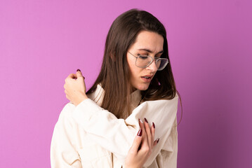 Young woman over isolated purple background with pain in elbow
