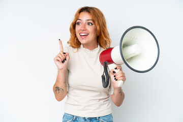 Young caucasian woman isolated on white background holding a megaphone and intending to realizes the solution - obrazy, fototapety, plakaty