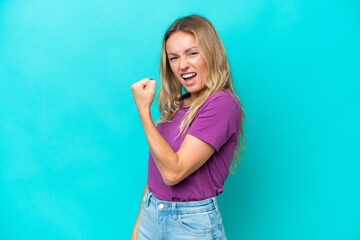 Young Russian woman isolated on blue background celebrating a victory