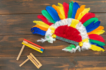 Indian headdress roach and traditional toys noisemakers for Jewish holiday Purim over dark wooden...