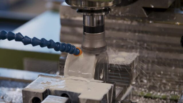 A spinning CNC machine cutting a wet cilinder of aluminium