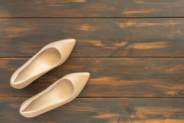 Women's heeled shoes on dark wooden background.