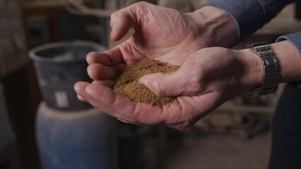A man holding animal meal in his hands