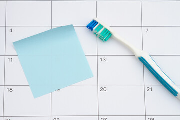 Dental appointment with toothbrush and sticky note on a calendar