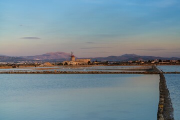 view of the windmill and salt flat museum of Paceco at sunset
