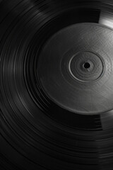 Textured surface of a vinyl record, featuring grooves and concentric rings. Vinyl record textures offer a retro and nostalgic backdrop