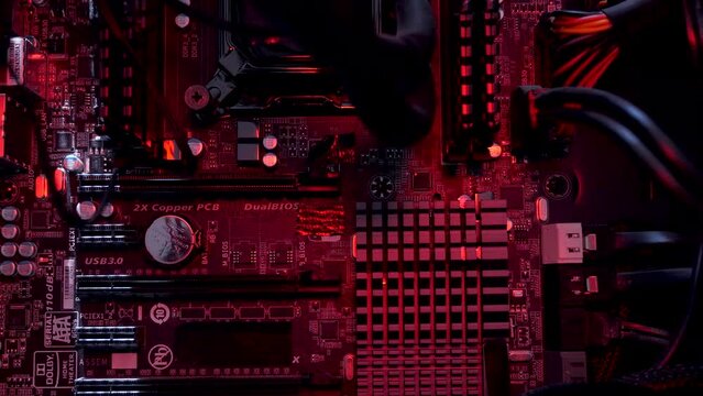 Inside View Of Computer Motherboard Seeing Heatsinks, Capacitors, DIMM and PCI Slot With RGB Lighting, Macro Shot, Dolly Right