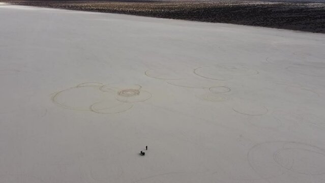 High aerial orbits motorcycle rider on expansive Pampe del leoncito