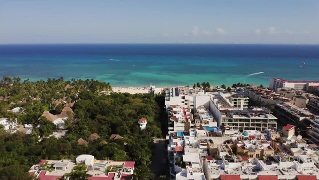 Aerial view of the beach and the coast of Pkaya del carmen in Cancun Quintana Roo. There are trees, sand and buildings in the town in a sunny day.