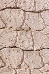 Background, texture of the wall made of uneven stone tiles. Close-up photograph of a surface.
