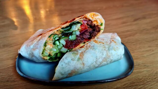 Closeup shot toasted wrap with fresh cucumber pita bread, red beans paste inside