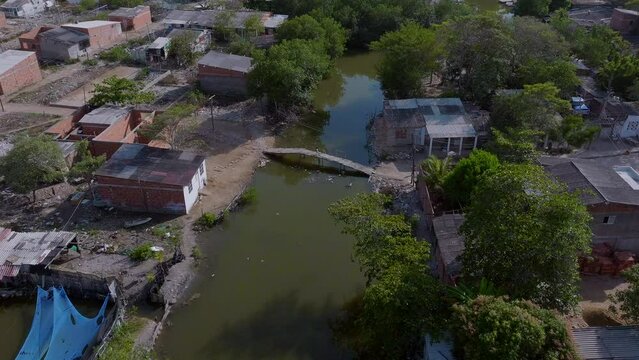 Aerial drone shot over poor neighborhood in Cartagena and a child crosses the bridge