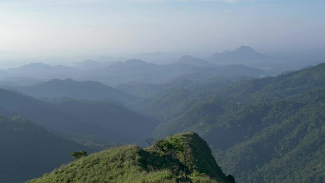 Slow motion SLR scenic landscape rolling hills forest mountain range cliffs on horizon cloudy in Little Adam`s Peak hiking trail Ella Kandy Sri Lanka Asia