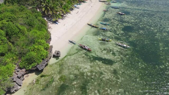 Aerial view of the traditional wooden fishing boats moored at Pontod Beach in Siquijor, Philippines