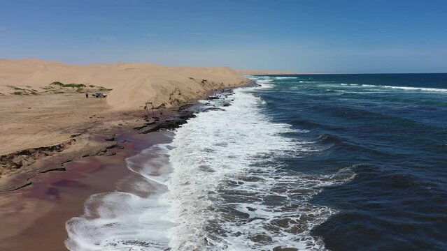 Drone footage of the Atlantic Ocean waves on the rocky shore of Sandwich Harbour Historic, Namibia